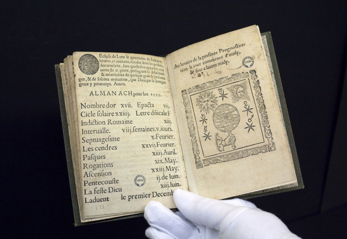A 16th-century edition of predictions by Nostradamus, the first book to be digitised by Google from a collection of 500,000 at the Municipal Library of Lyon, is displayed by a librarian in this January 15, 2010 file picture. Amid the flat, wide fields of central France, a team of re-trained secretaries and IT experts is packaging Europe's literary heritage for the digital era. To match feature FRANCE-BOOKS/ REUTERS/Robert Pratta/Files (FRANCE - Tags: SCI TECH SOCIETY) - RTR297PK